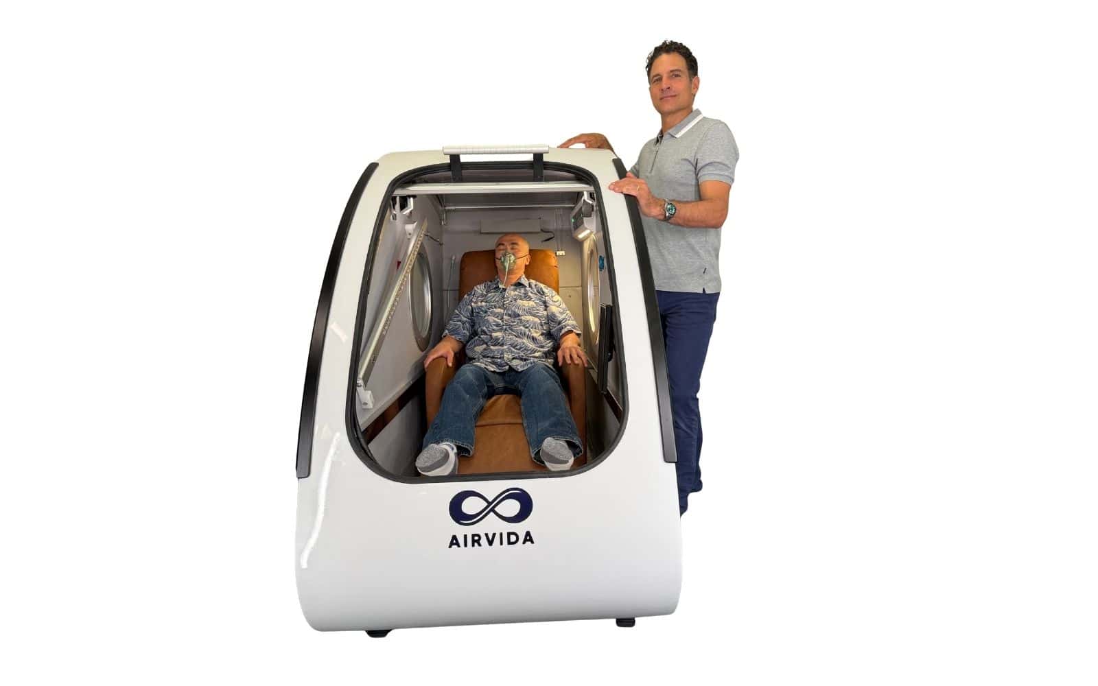 Dr. Adam Fields standing beside a patient relaxing inside an Airvida hyperbaric oxygen chamber receiving HBOT for depression.
